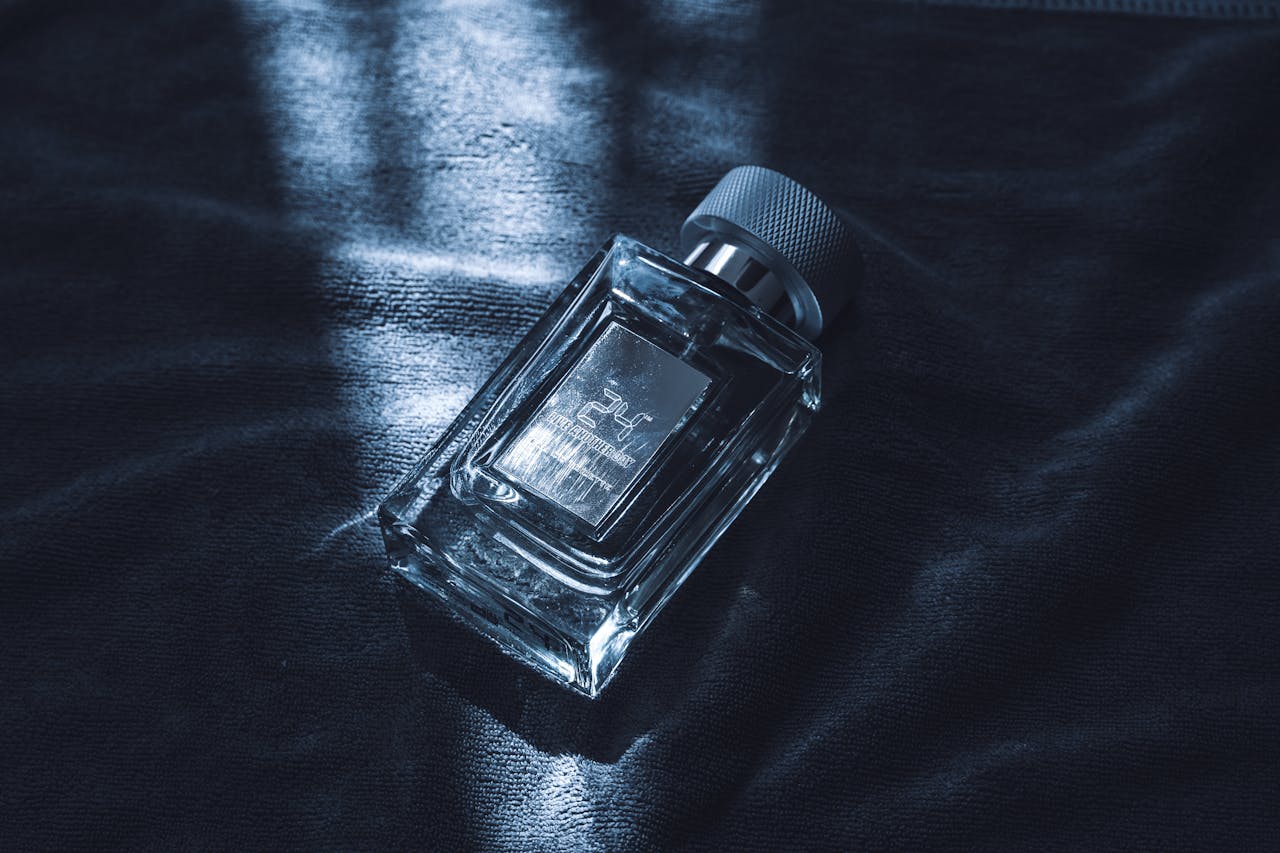 An artistic shot of a luxury perfume bottle resting on textured fabric, emitting sophistication.